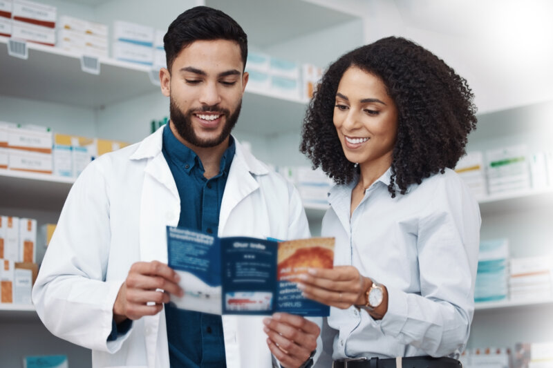 Healthcare professionals looking at a brochure in a pharmacy setting